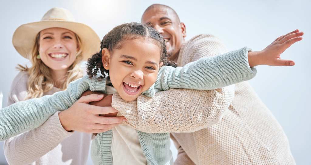 Parents and child playing together on a beach, representing peace of mind and confidence through completed estate planning.